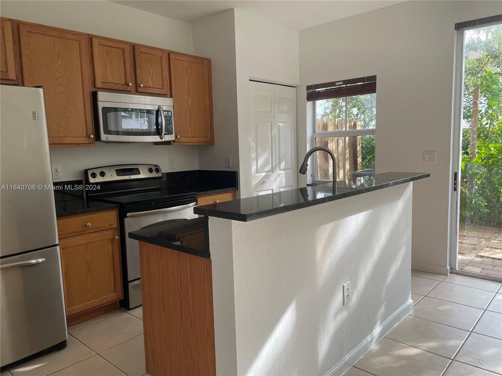 a kitchen with granite countertop a refrigerator and a stove