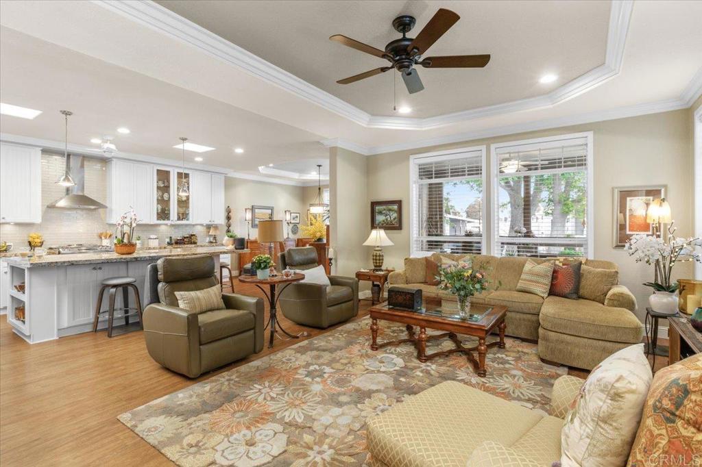 a living room with furniture kitchen view and a large window