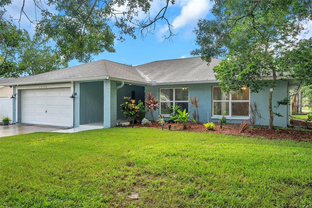 a view of a house with a yard and porch