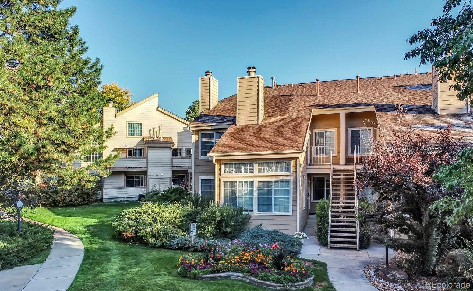 a front view of a house with a yard and potted plants