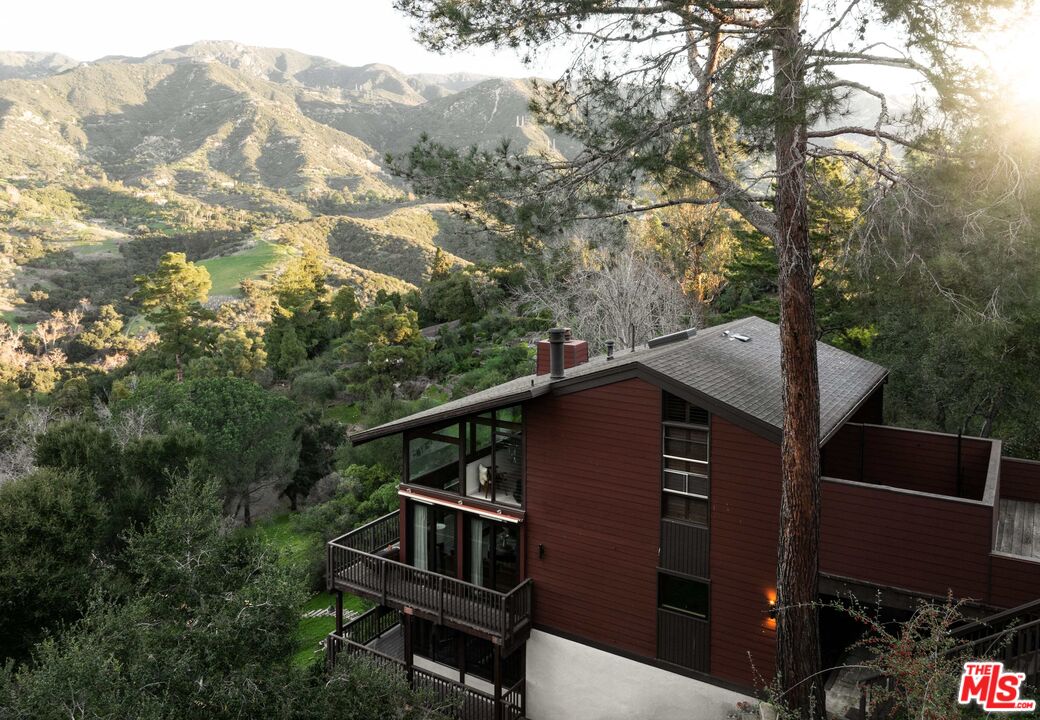 a view of a house with a mountain from a balcony