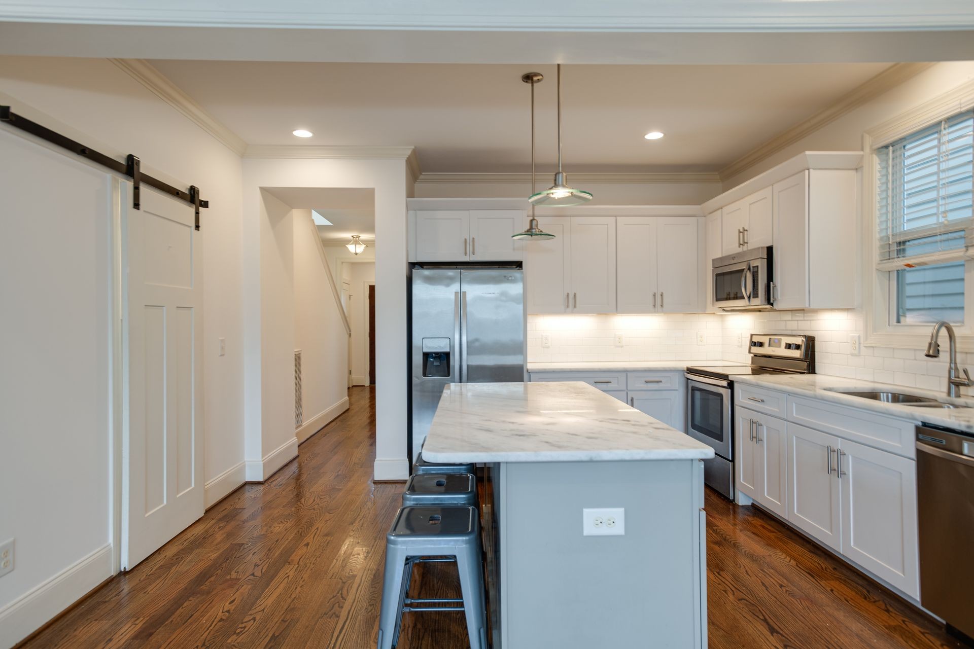 a kitchen with kitchen island a counter top space a sink stainless steel appliances and cabinets