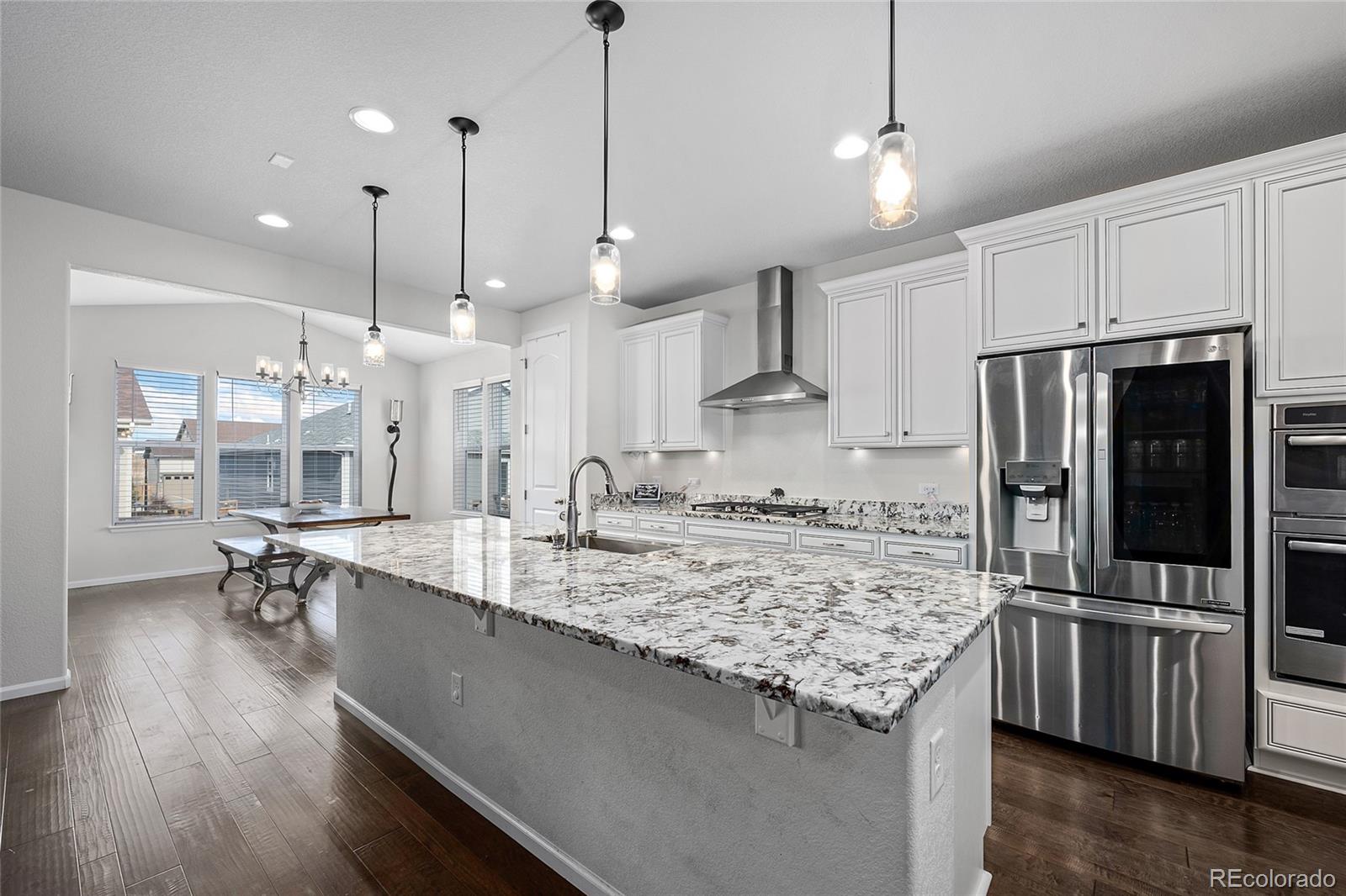 a kitchen with stainless steel appliances granite countertop a sink a stove and refrigerator