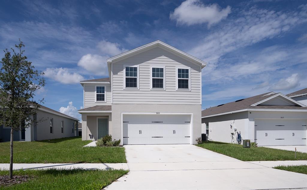 a front view of a house with a yard and garage