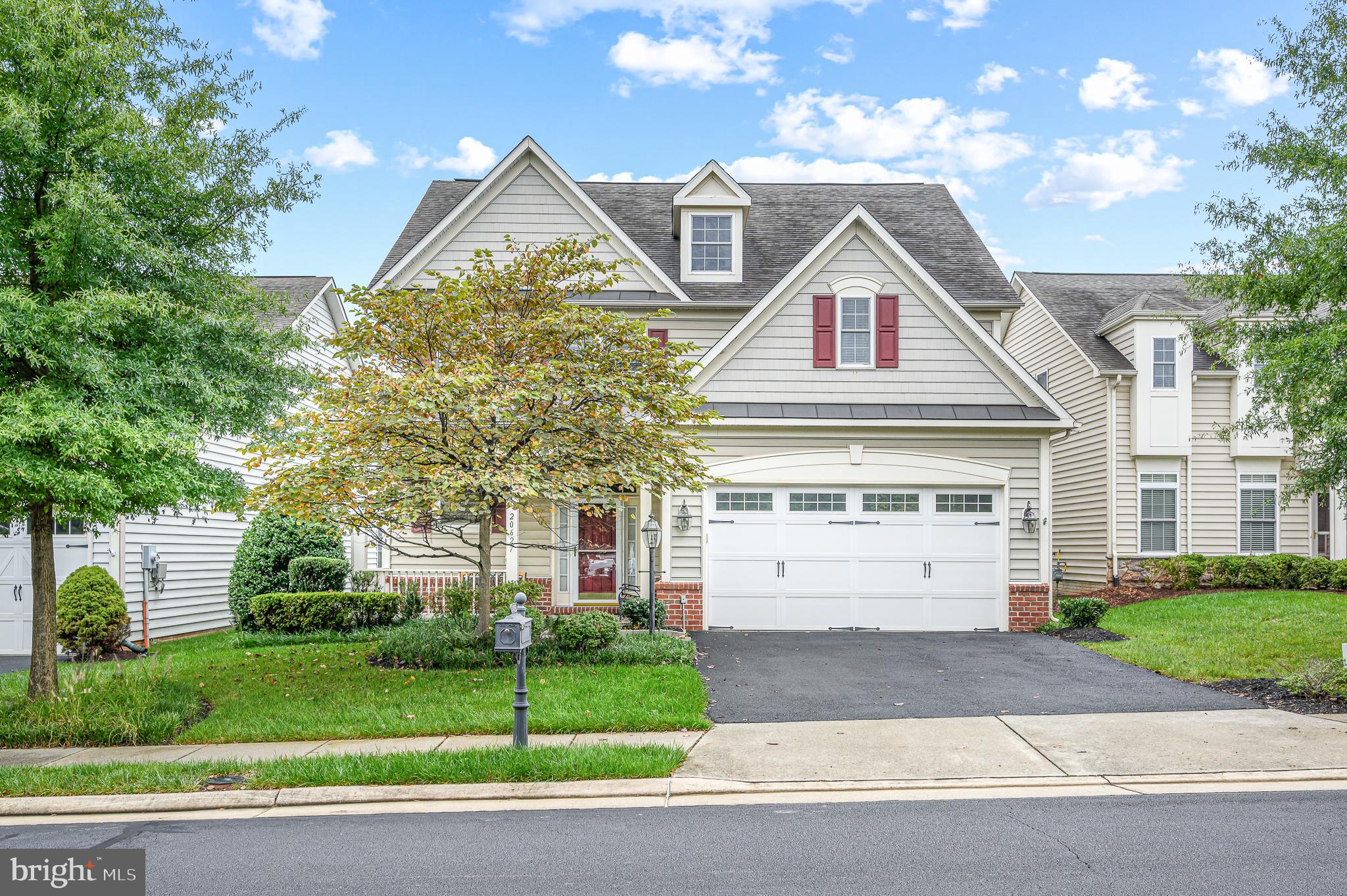 a front view of a house with a yard and a garage