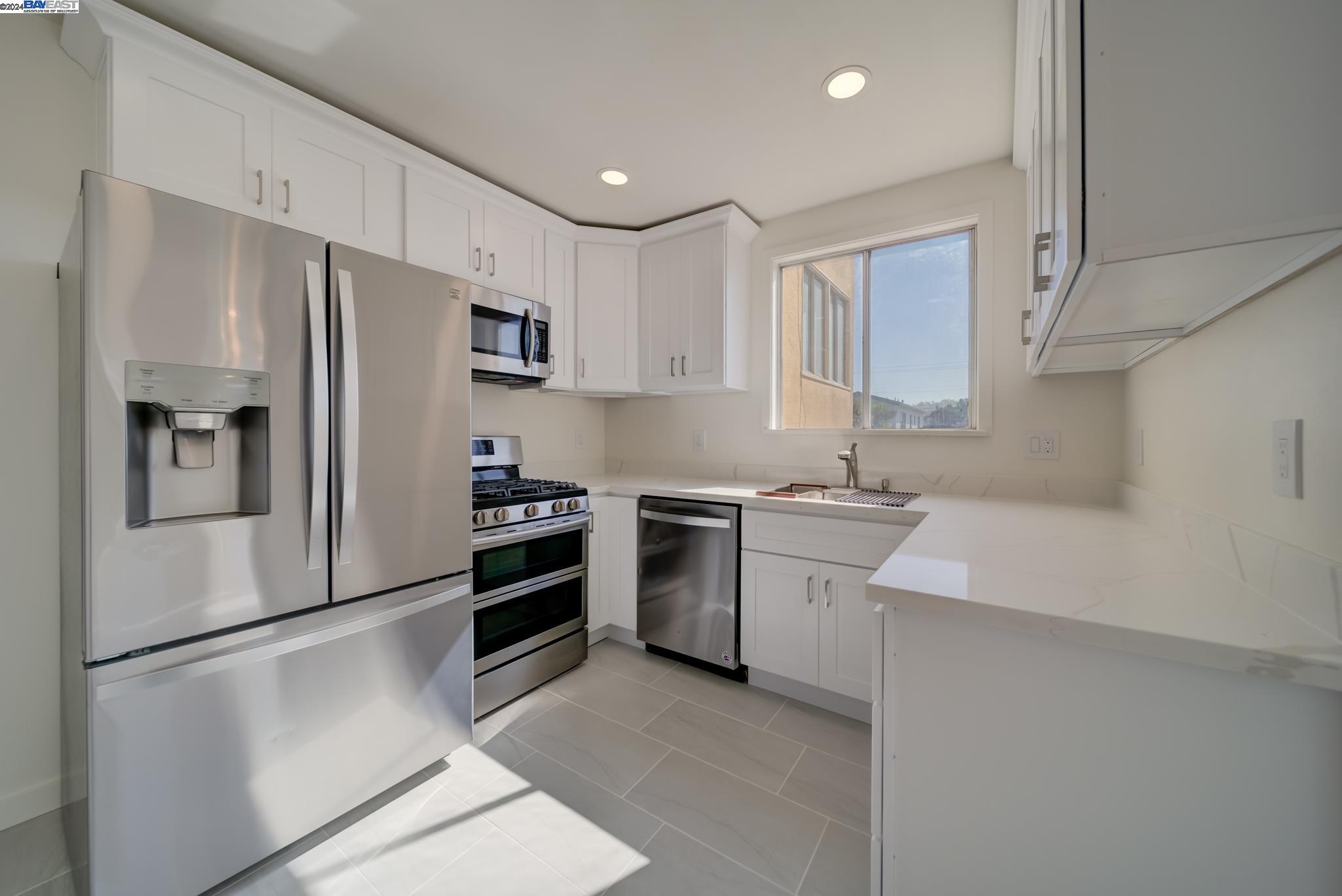 a kitchen with stainless steel appliances a refrigerator sink and stove