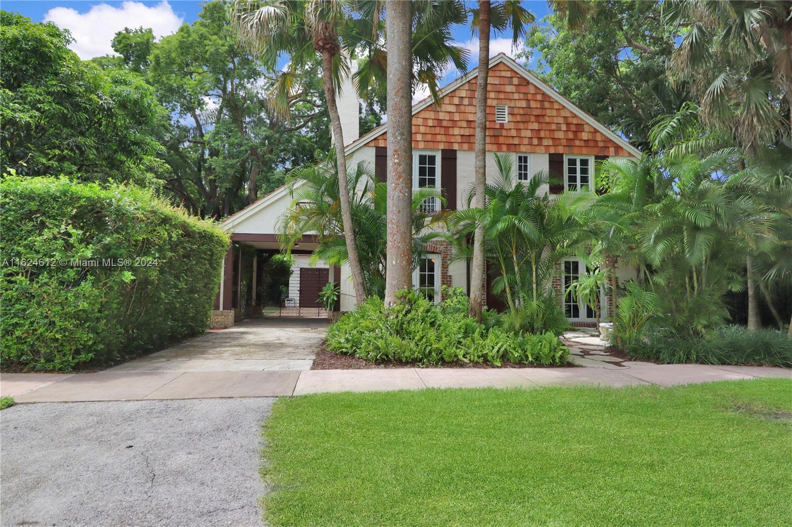 a front view of a house with a yard and trees