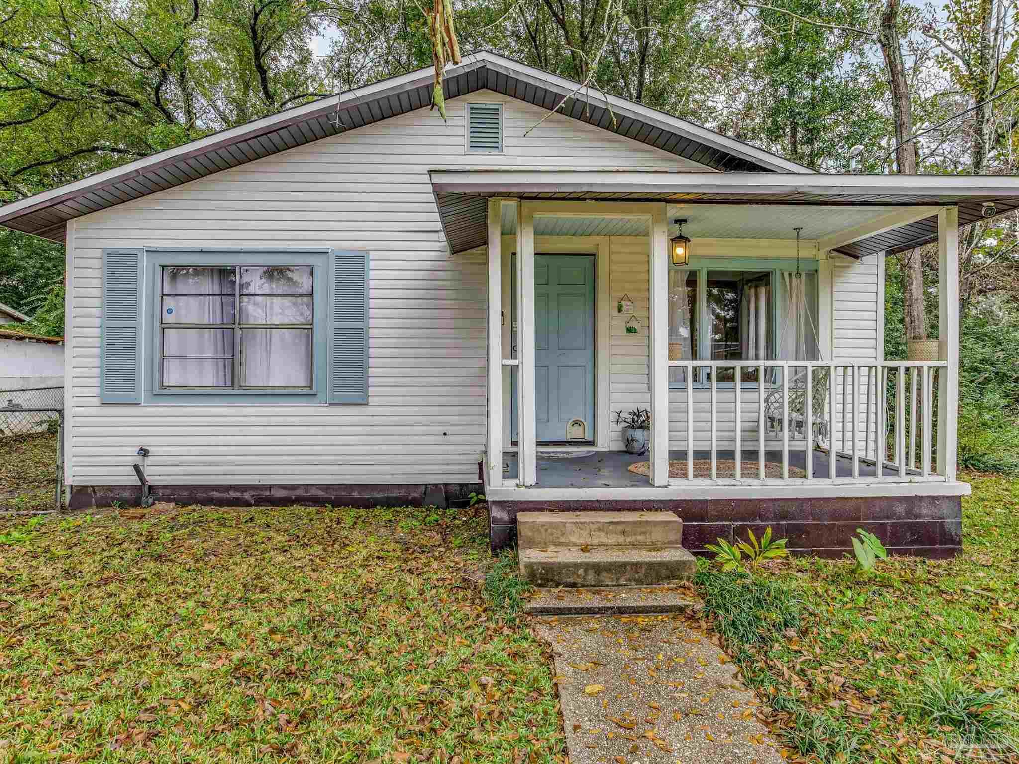 a view of a house with a small yard and wooden floor and fence