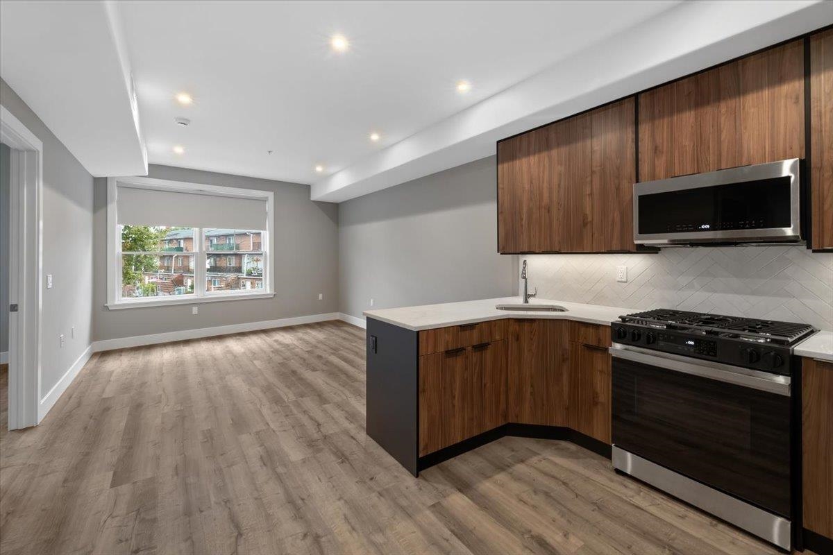 a kitchen with wooden floors a sink a stove and microwave