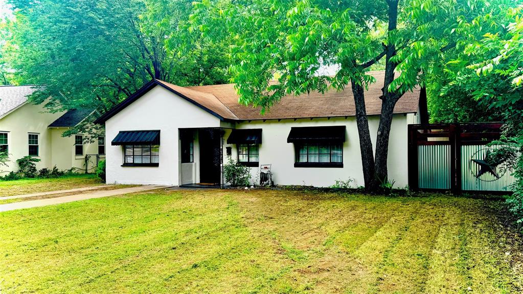 a view of a house with a yard and a tree