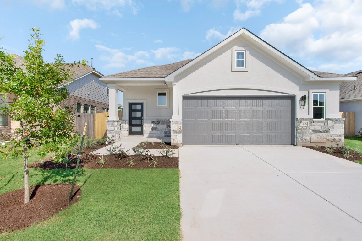 a front view of a house with a yard and garage