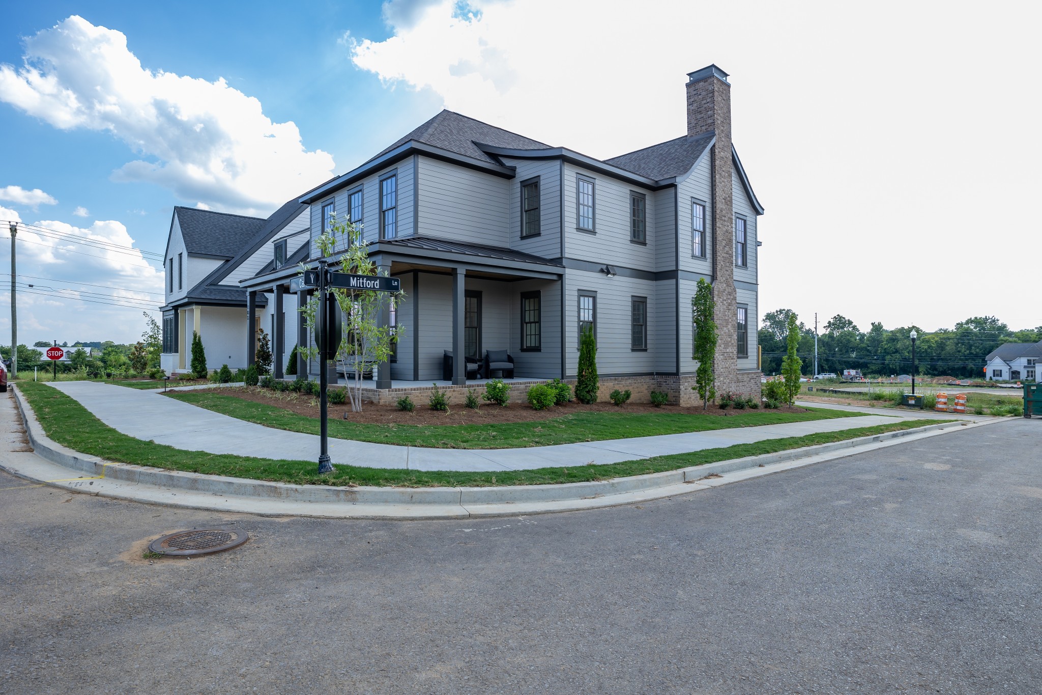 a view of a big house with a big yard and large trees