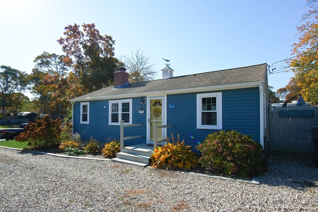 a view of a house with a yard and large tree