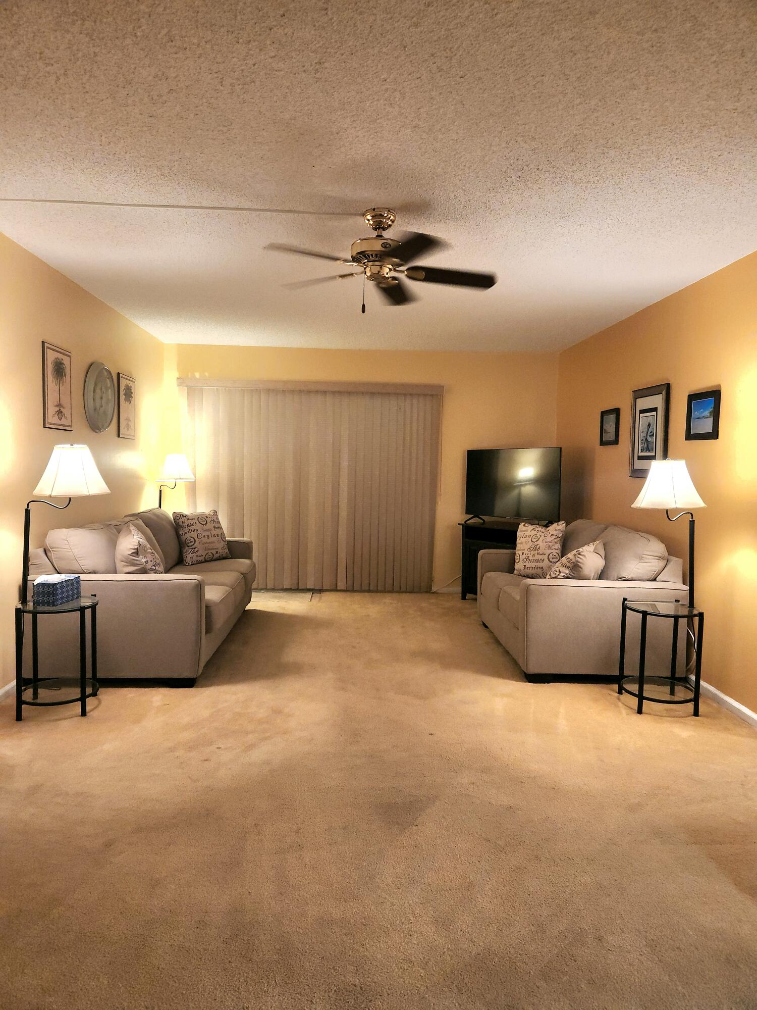 a living room with furniture and a ceiling fan