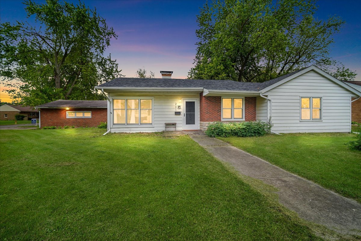 a front view of a house with yard and green space