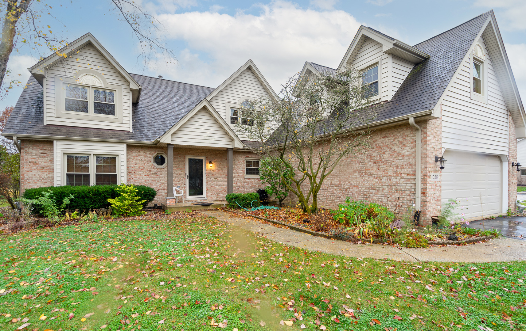 a front view of a house with a yard and potted plants