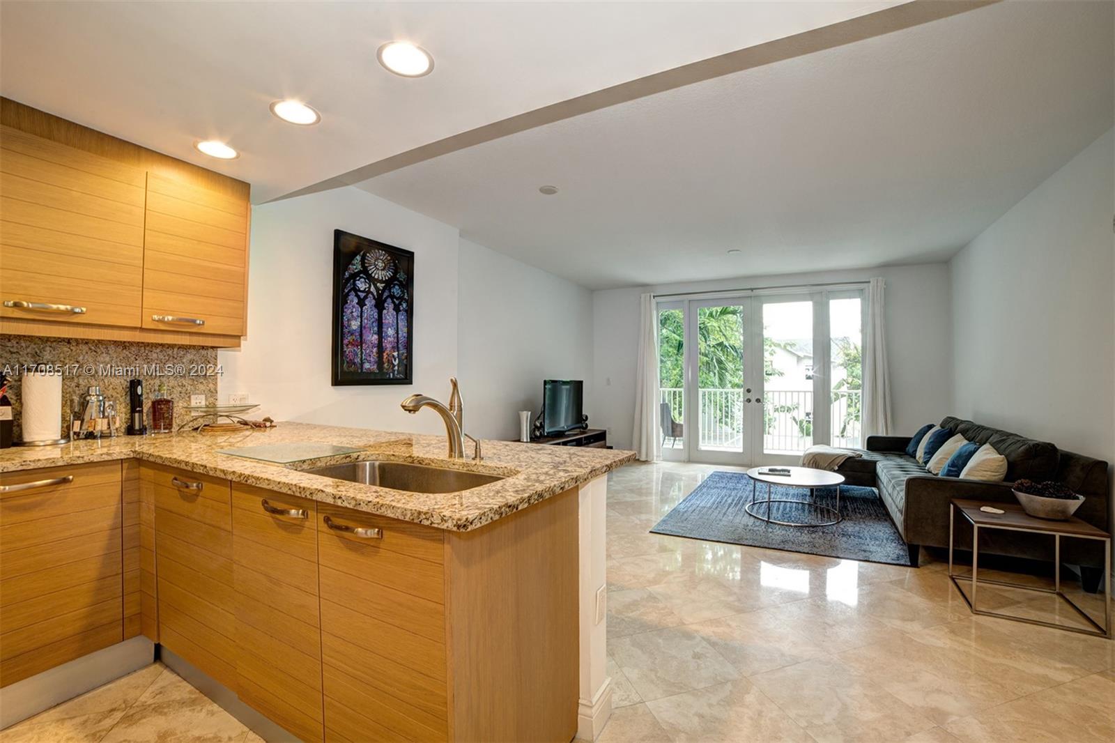 a living room with granite countertop furniture and a open kitchen view