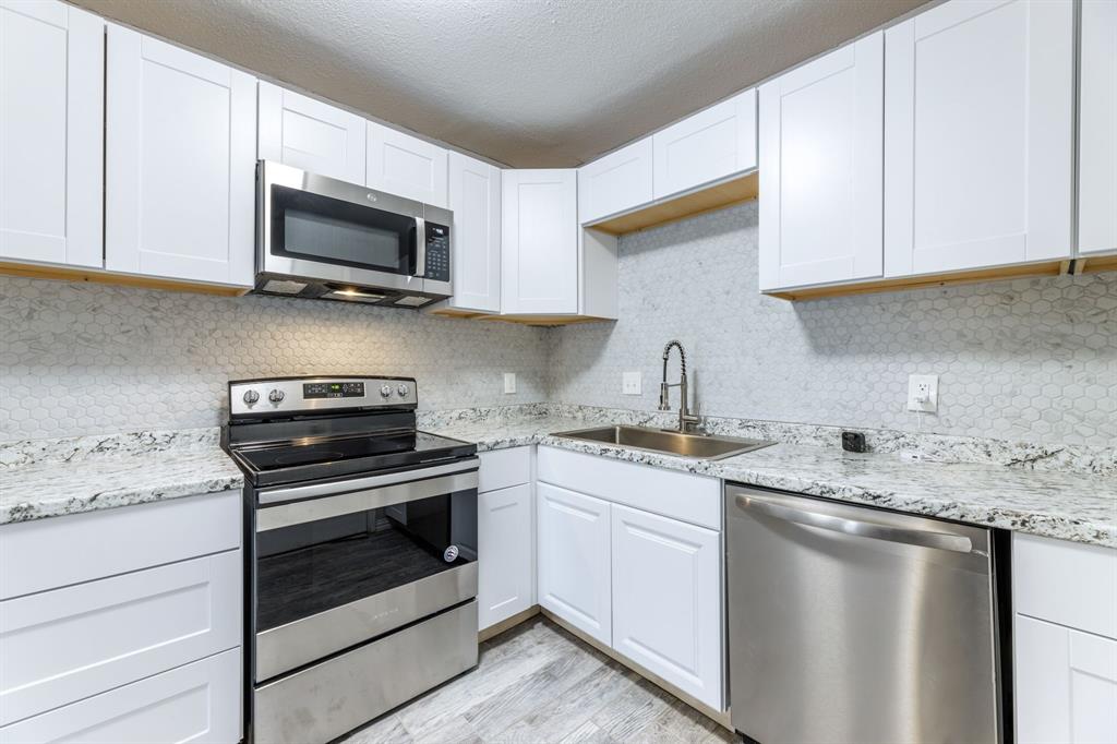 a kitchen with appliances a sink and cabinets