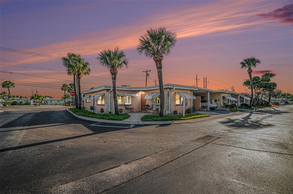 a front view of a house with palm trees