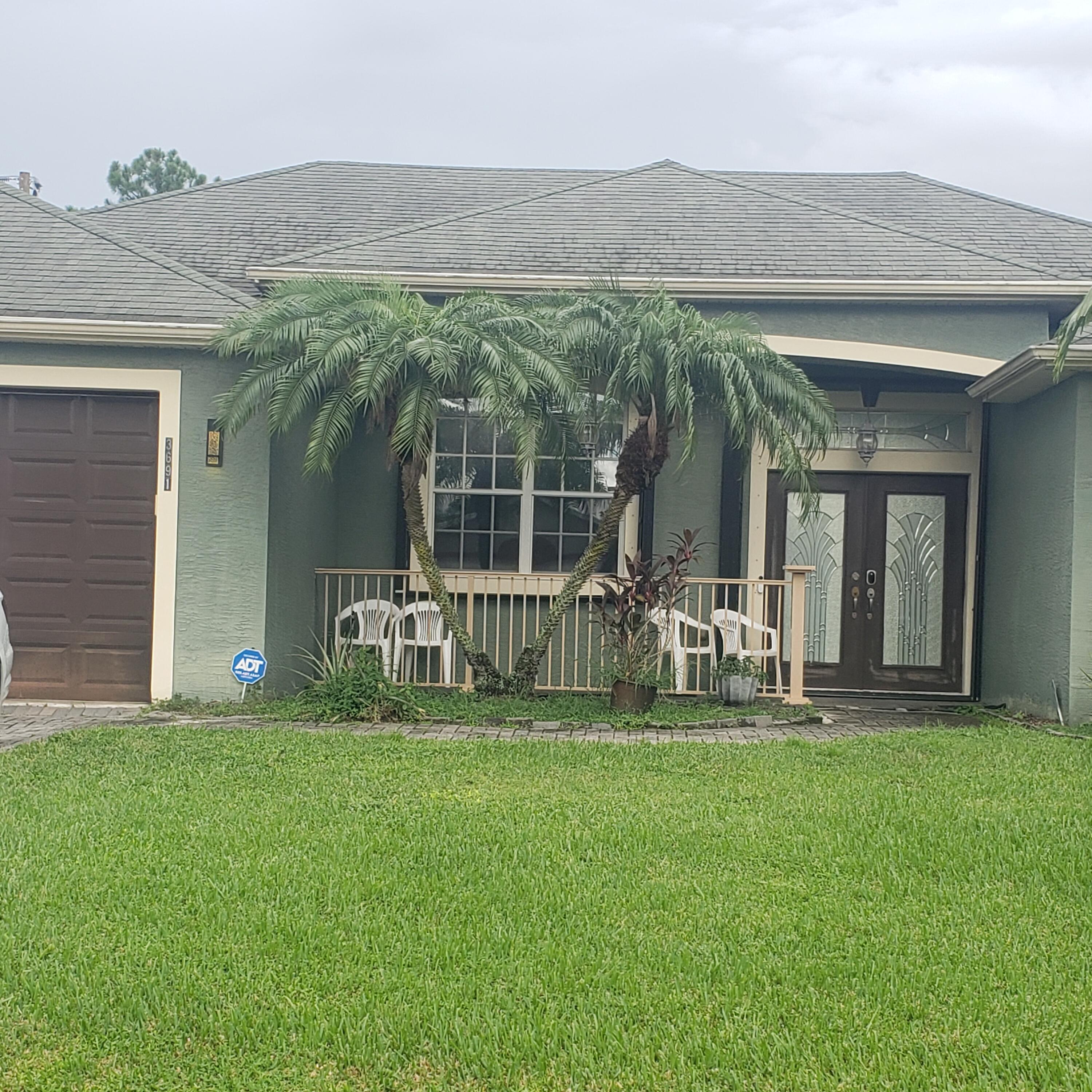 a front view of a house with two big yard and a fountain