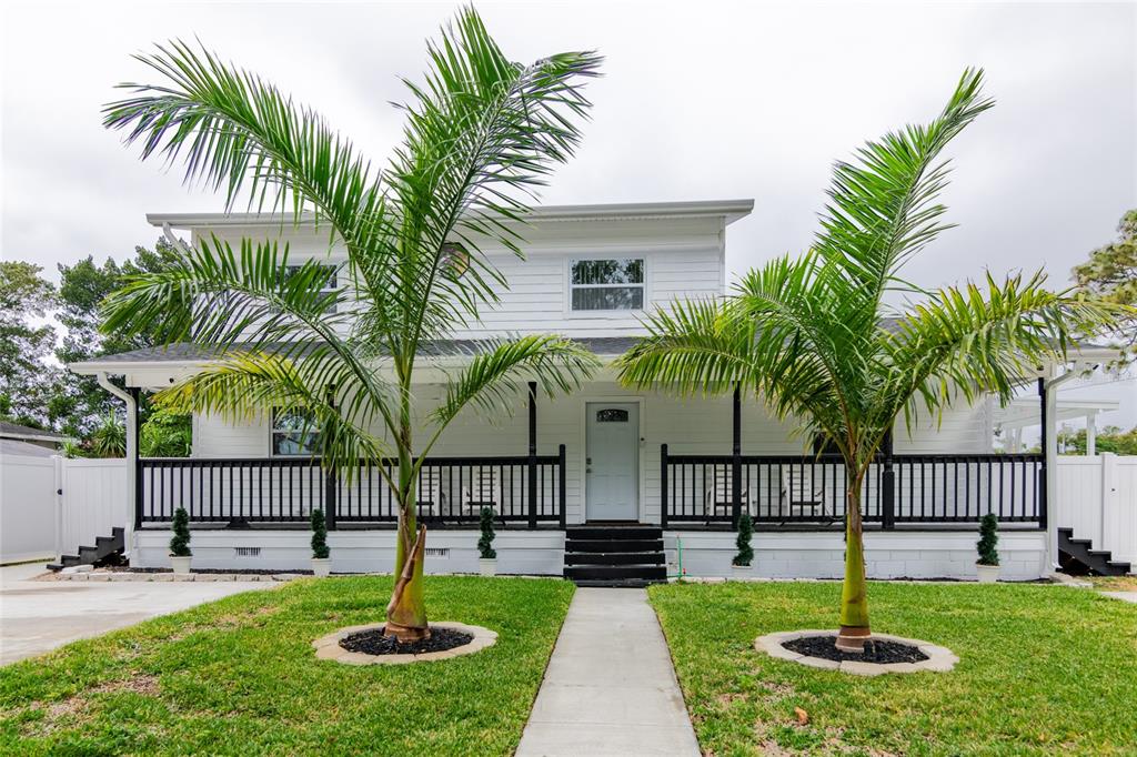 a front view of a house with swimming pool and porch