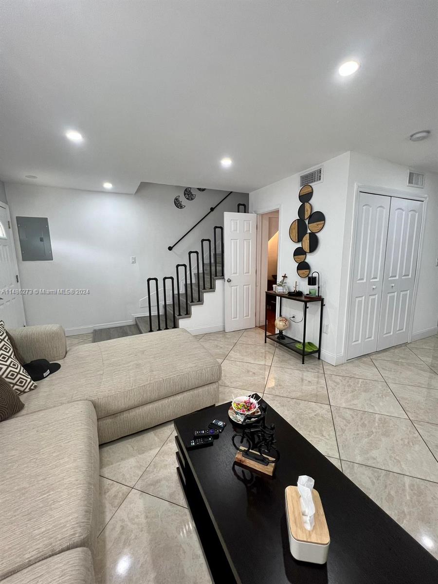 a living room with furniture and wooden floor