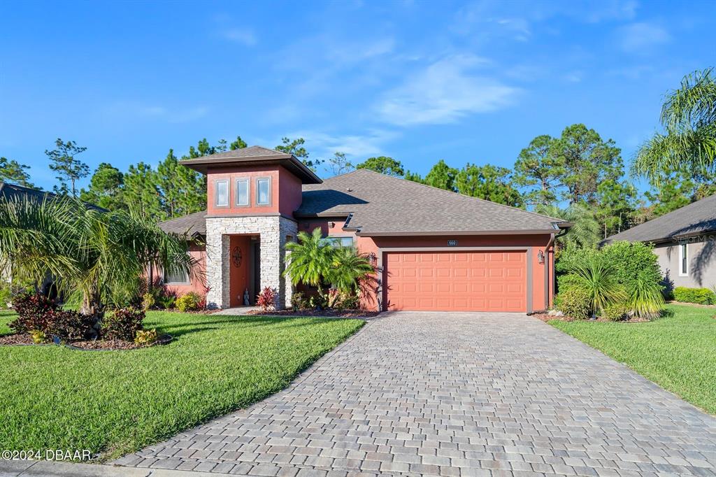 a front view of a house with a yard and garage