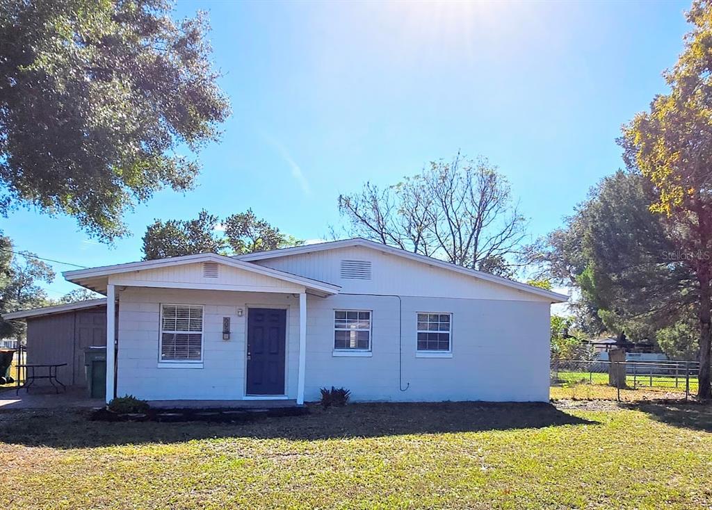 a front view of house with yard and trees in the background