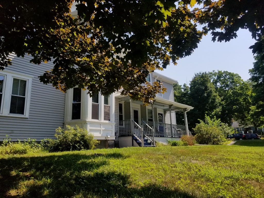 a view of a house with backyard and sitting area