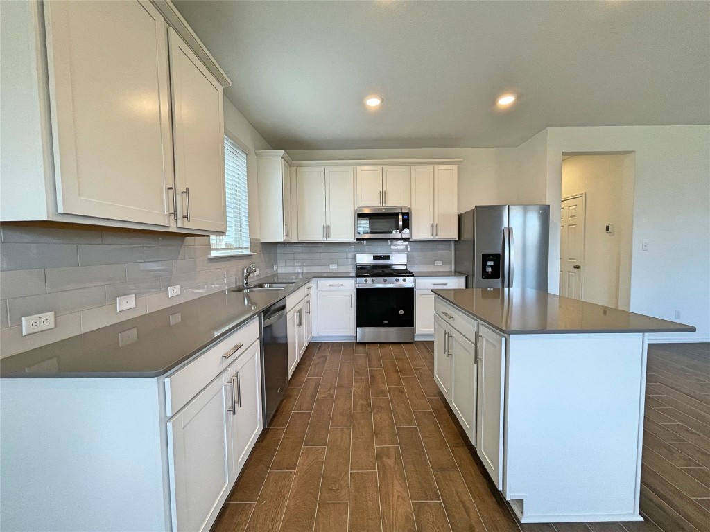 Welcome Home! Feast your eyes on this sleek, modern kitchen featuring stainless steel appliances and a center island.