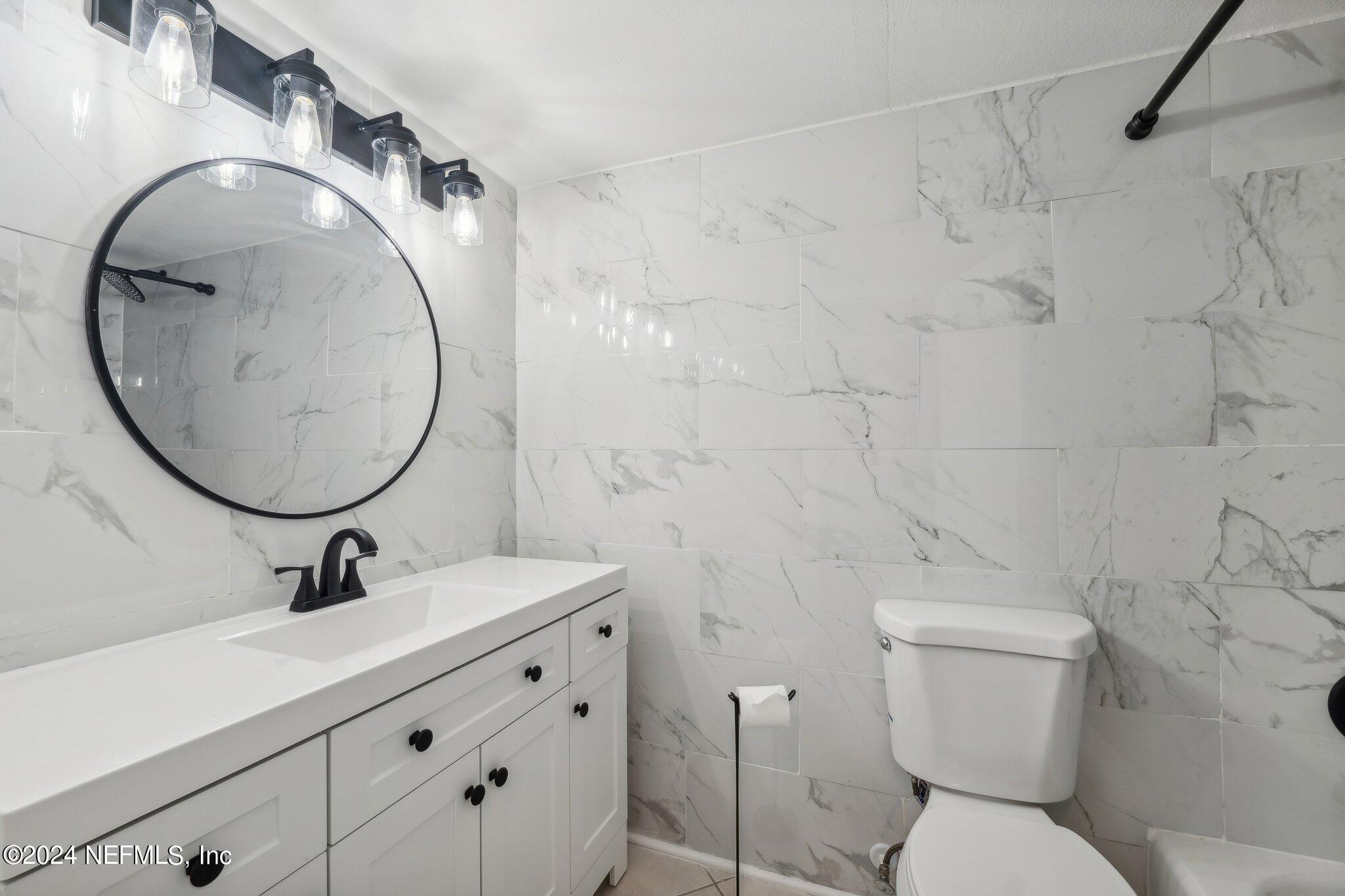 a bathroom with a sink mirror vanity and toilet