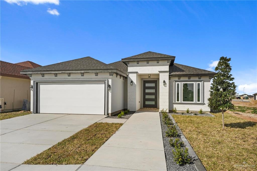 Prairie-style home with a front lawn and a garage