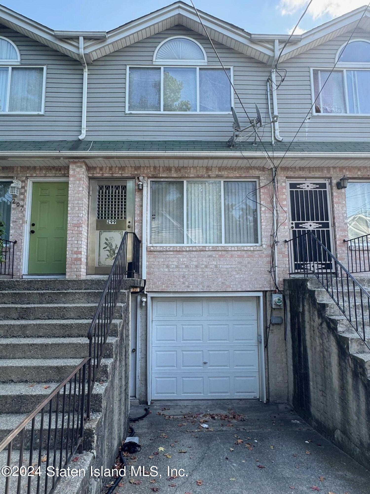 a view of a house with a garage and large windows