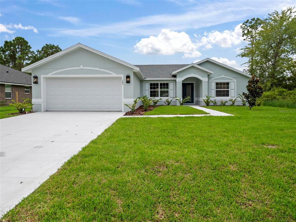 a front view of a house with a yard and garage