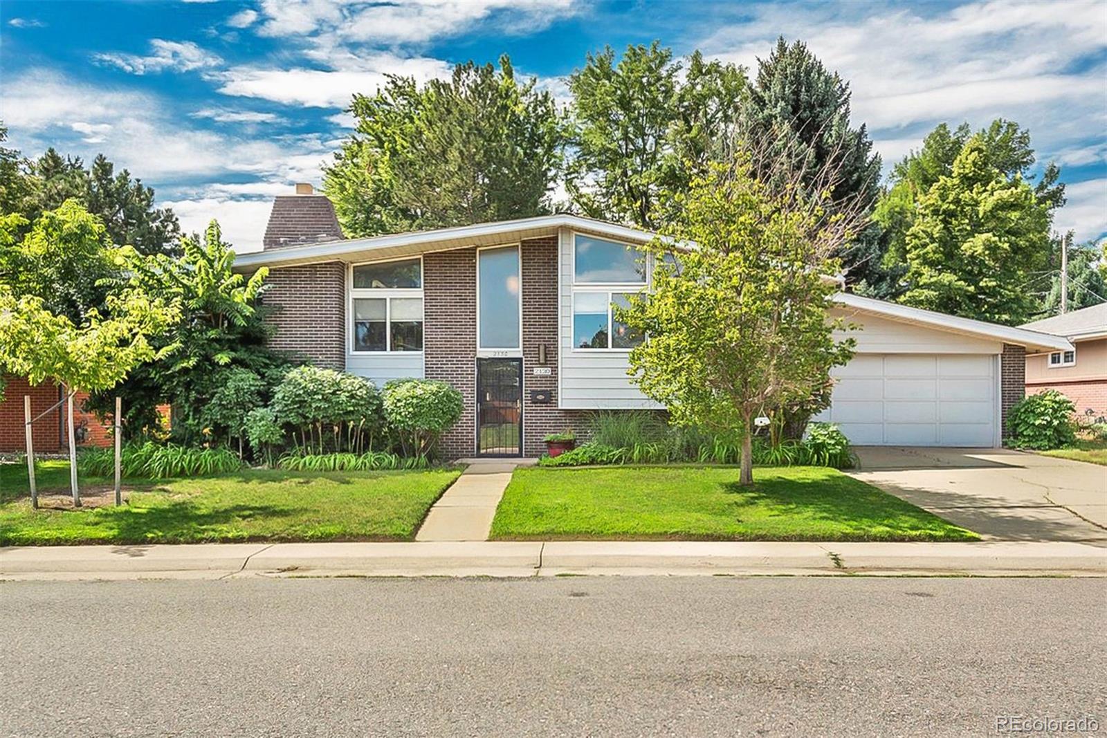 a front view of a house with a yard and a garage