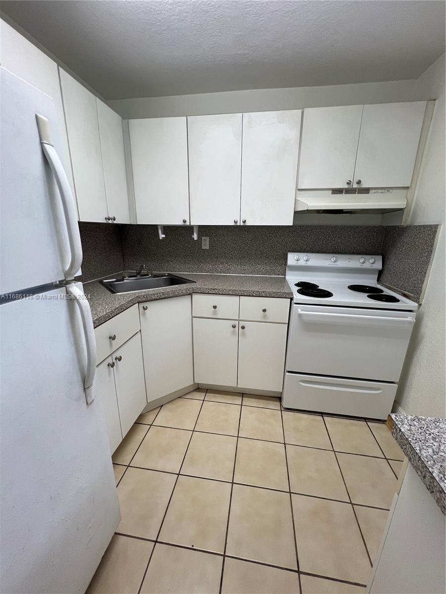 a kitchen with a stove a sink and a refrigerator