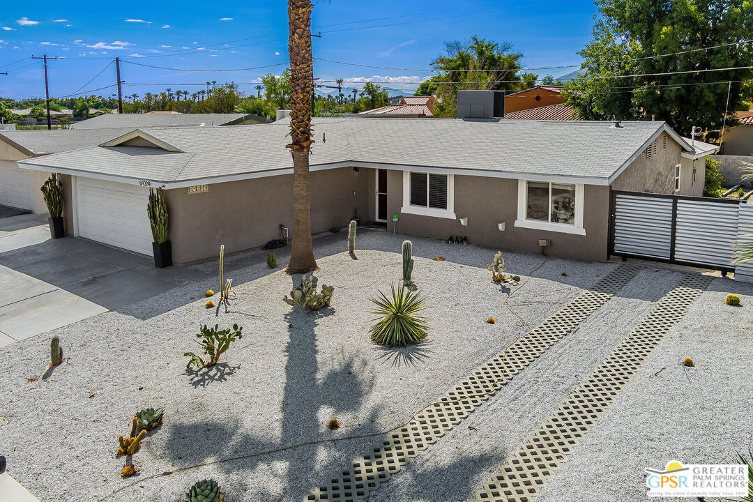 a view of a house with backyard and sitting area