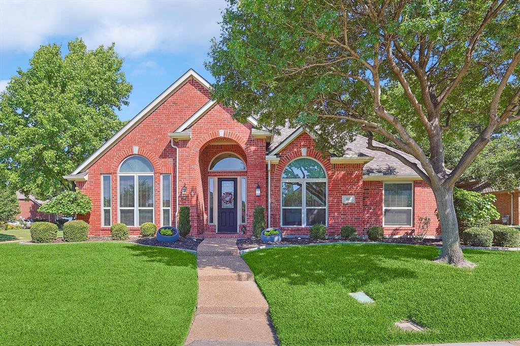 a front view of a house with yard and green space