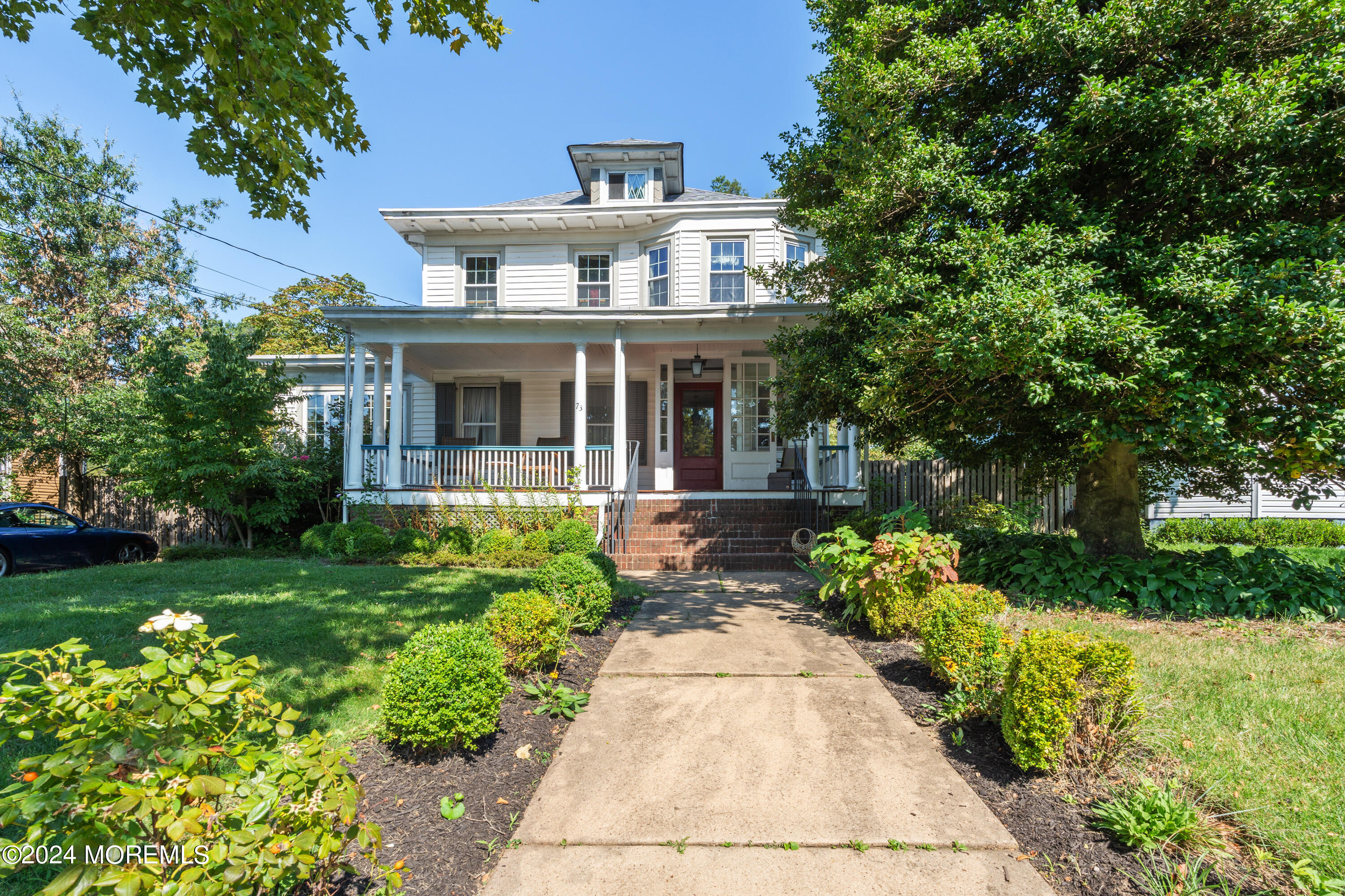 a front view of a house with a yard and potted plants