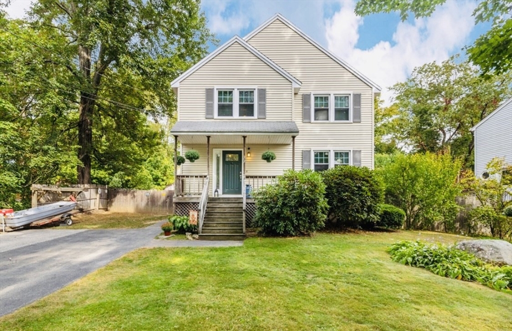 a front view of a house with a yard and trees