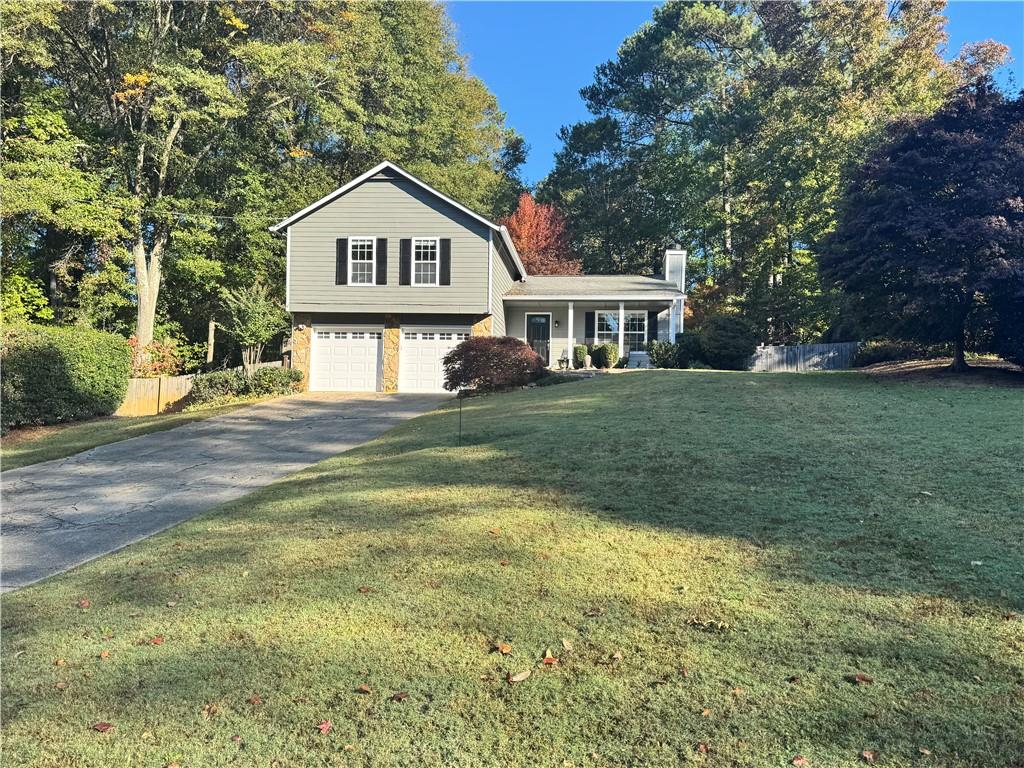 a front view of a house with a yard and trees