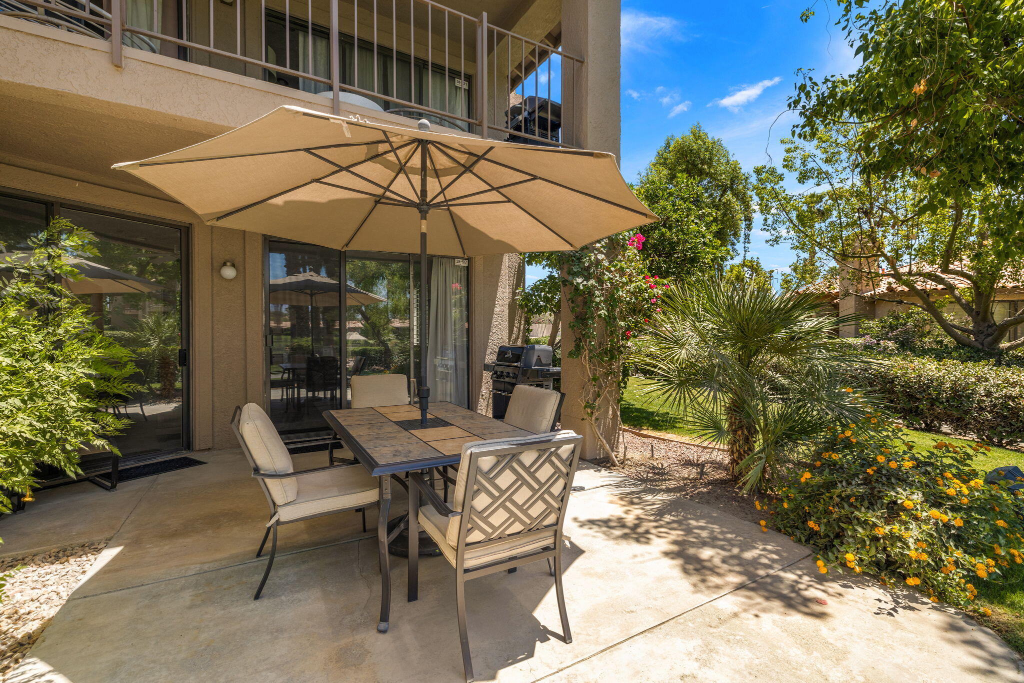 a patio with a table and chairs under an umbrella