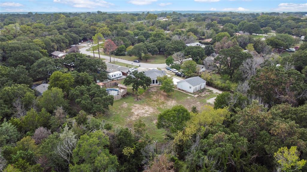 an aerial view of residential houses with outdoor space and trees