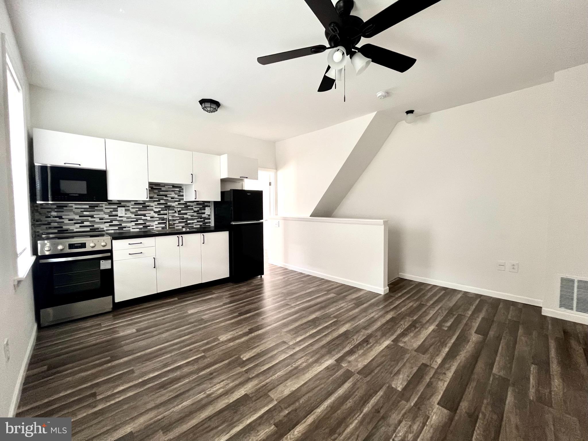 a kitchen with granite countertop a stove and a microwave oven