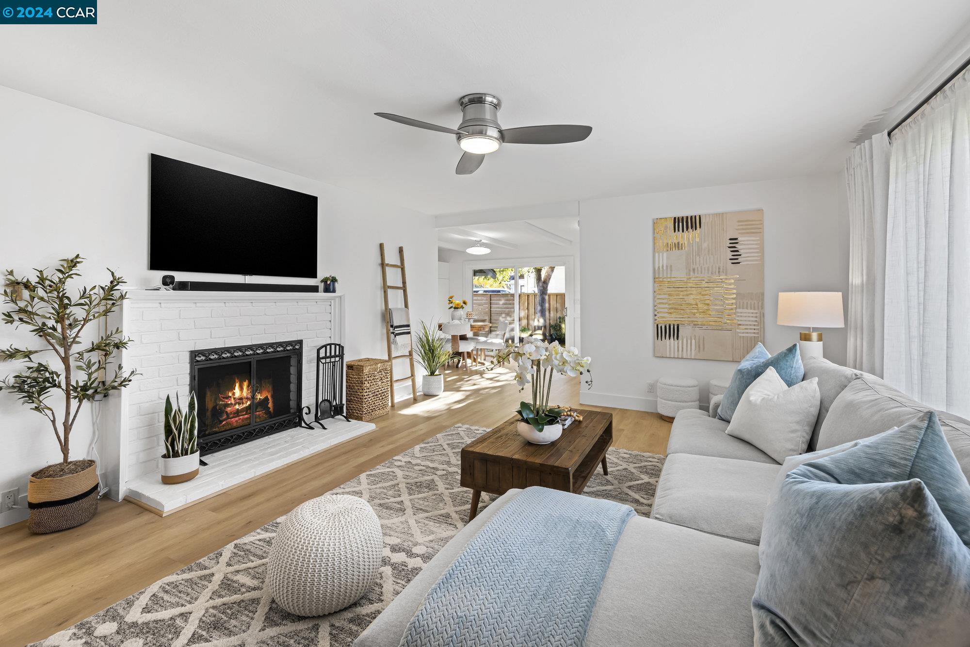 a living room with furniture a flat screen tv and a fireplace