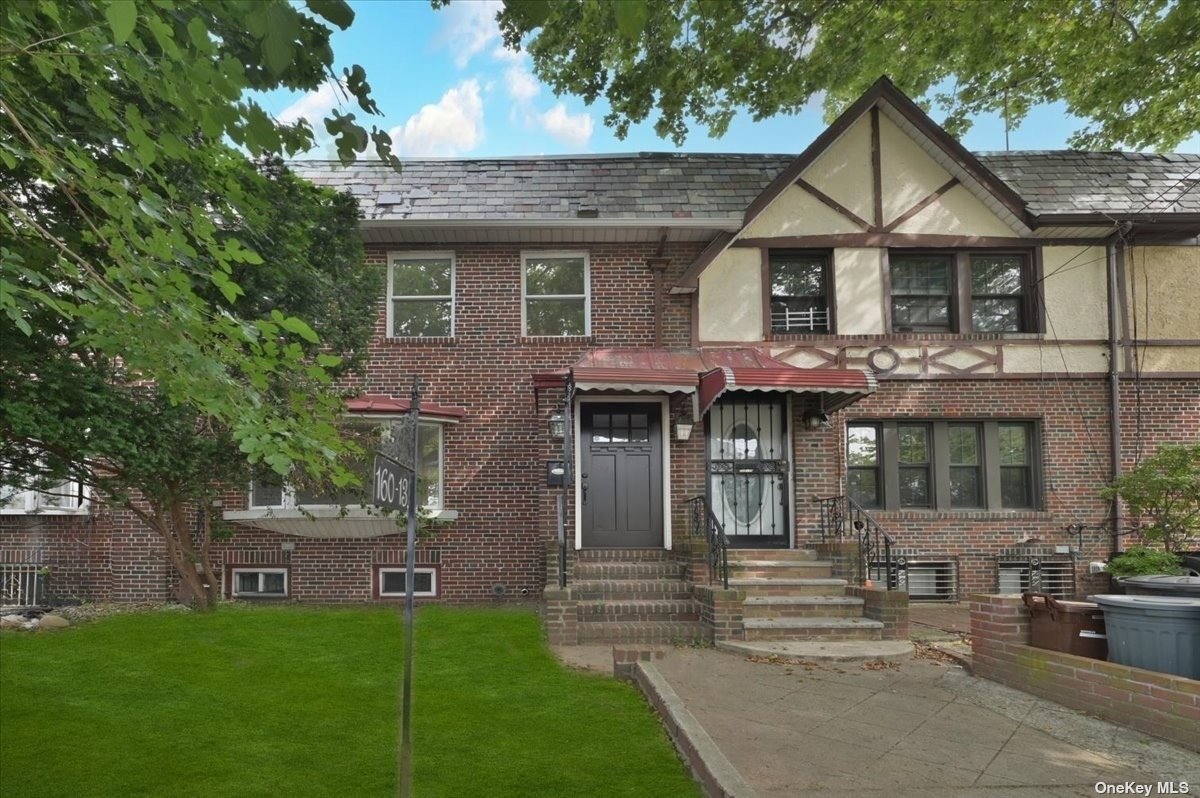 a front view of a house with a garden and plants