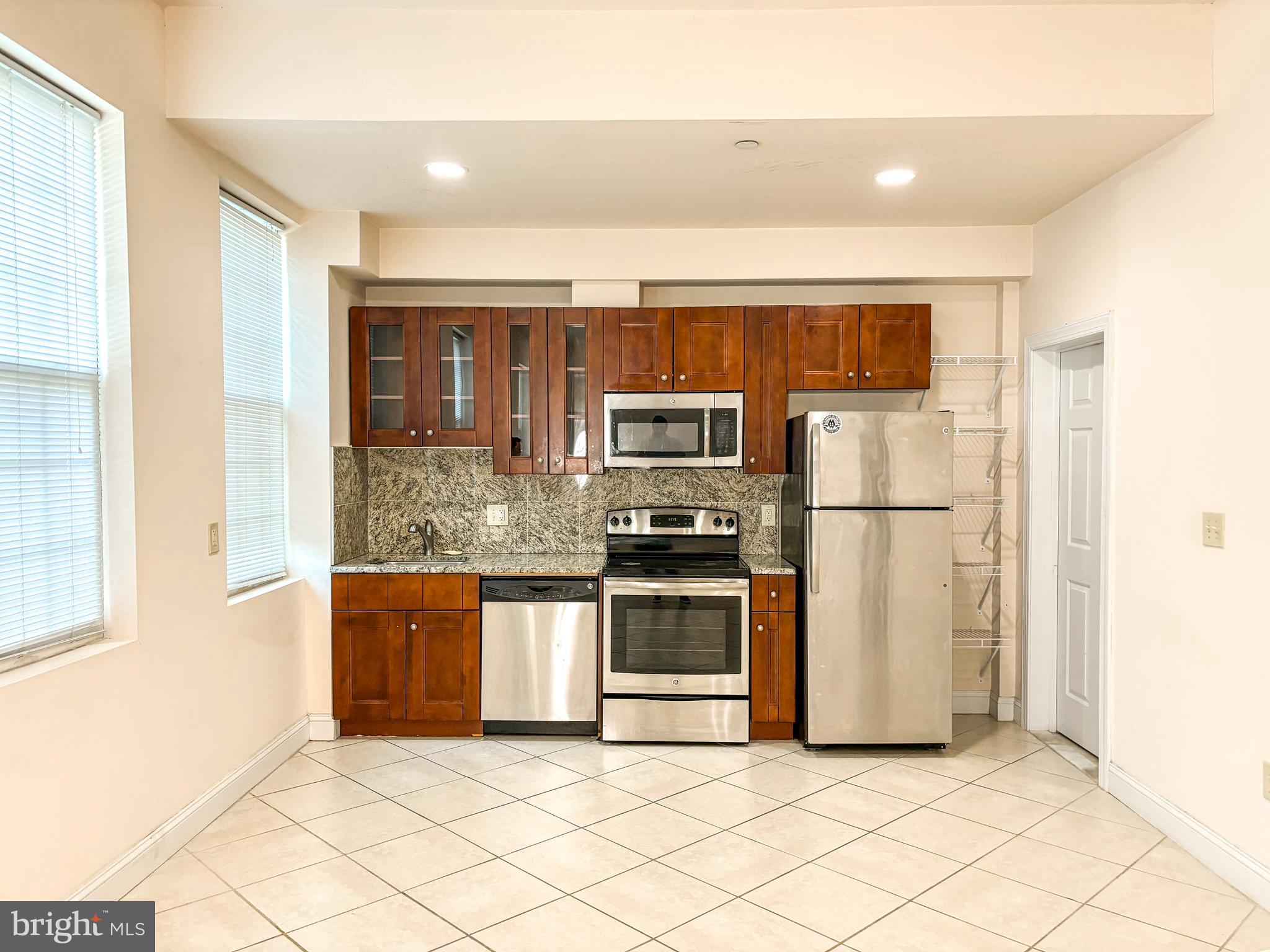 a kitchen with stainless steel appliances granite countertop a refrigerator and a stove