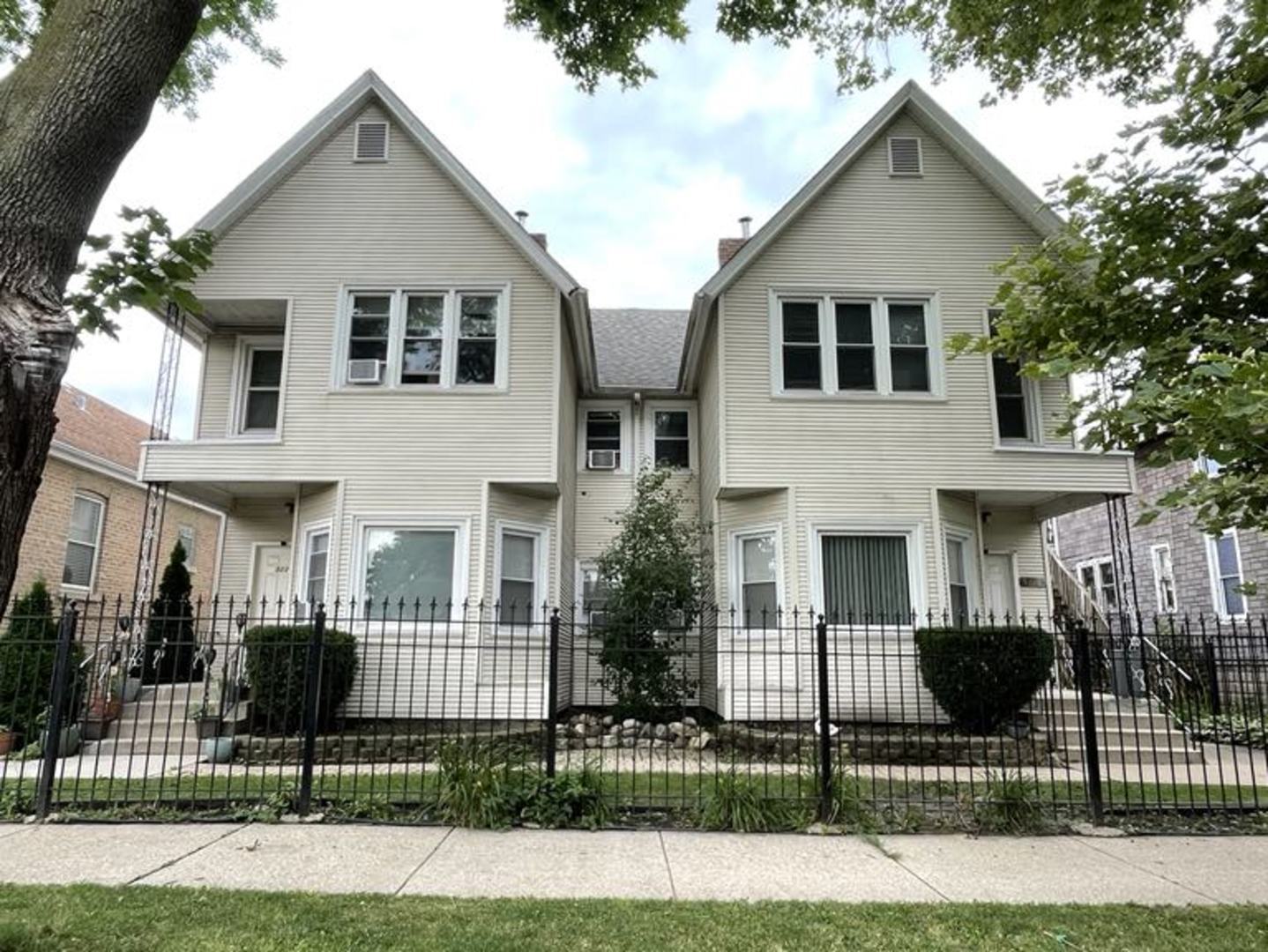 a view of a white house in front of a yard