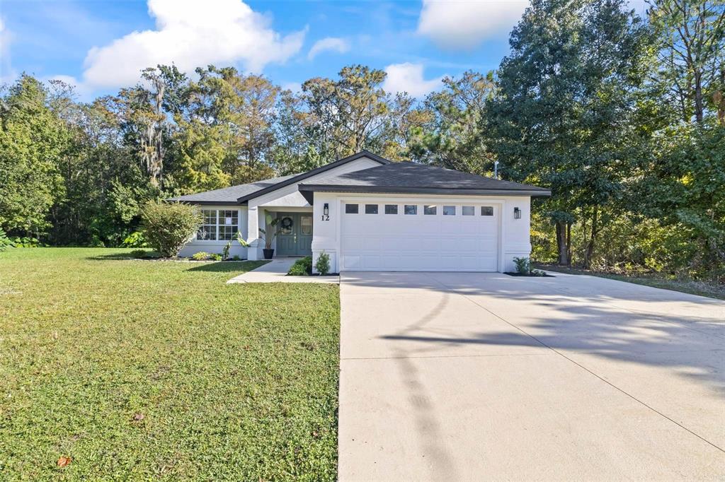 a front view of a house with a yard and trees