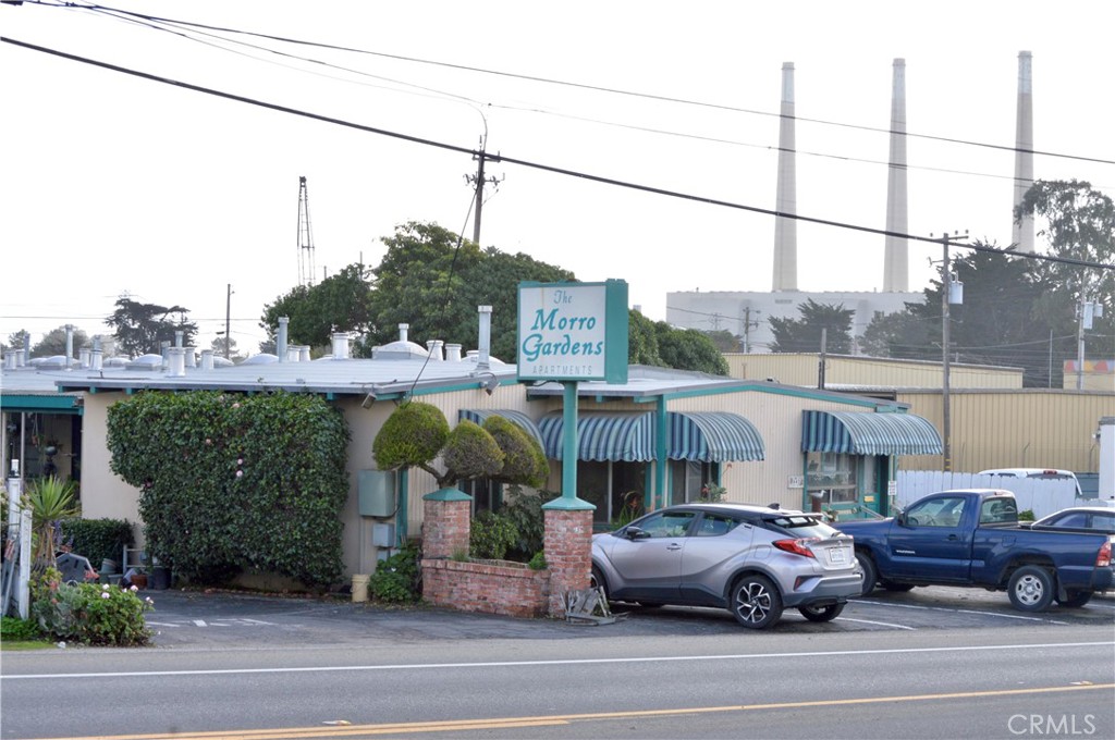 a front view of a building with cars parked